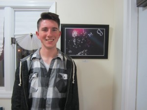 Noah Ost stands next to his manipulated photography titled “Space.”